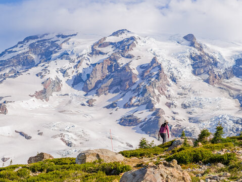 Hiker on ridge overlooking Mount Rainier glacier