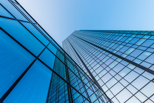 Modern blue glass office tower with sharp vertical perspective.