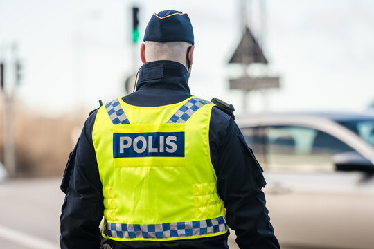 Uniformed traffic officer wearing reflective vest during roadside duty.
