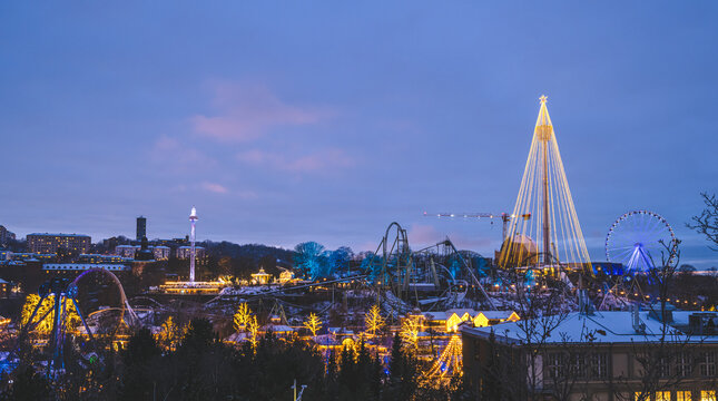 Winter amusement park glowing with festive lights at twilight.
