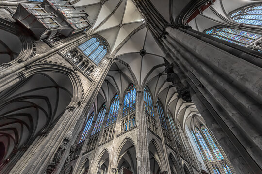 Dramatic gothic cathedral interior with vaulted ceiling and stained glass.