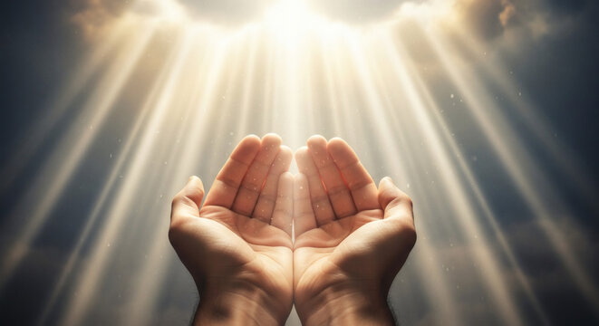 Open human hands reaching towards divine light rays descending from the heavens representing hope spirituality faith and peaceful prayer