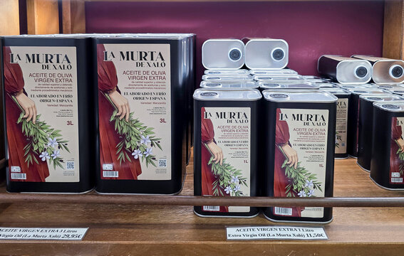 XALO, SPAIN - JUNE 20, 2026.Large metal tins of La Murta de Xal&oacute; extra virgin olive oil on display in a rustic wooden bodega
