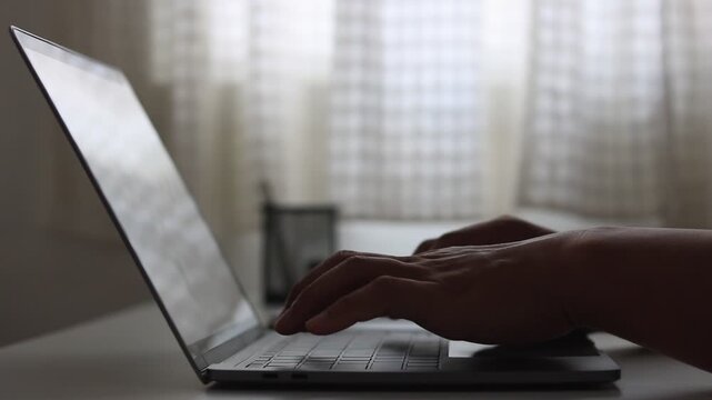Man hand typing on laptop computer keyboard at home or in office. Freelancer working, sending messages, chatting, browsing the internet and using social networking.  Programmer coding session software