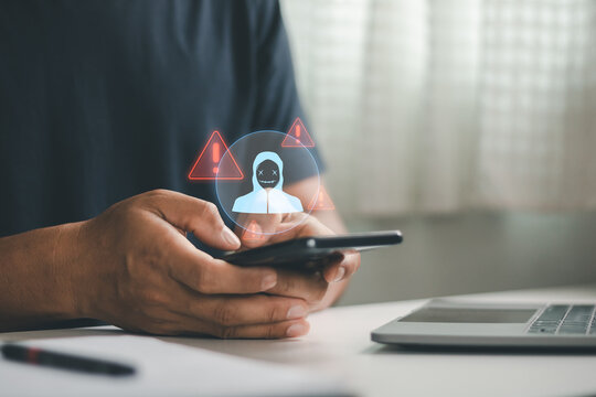 Person using smartphone with cybersecurity warning and hacker icon, illustrating mobile phishing, online scam, cyber attack, digital fraud, data protection, network security, privacy risk awareness.