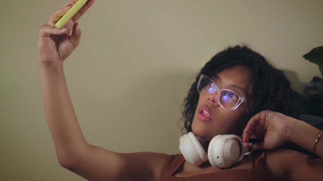 Young latina woman taking a selfie with a smartphone