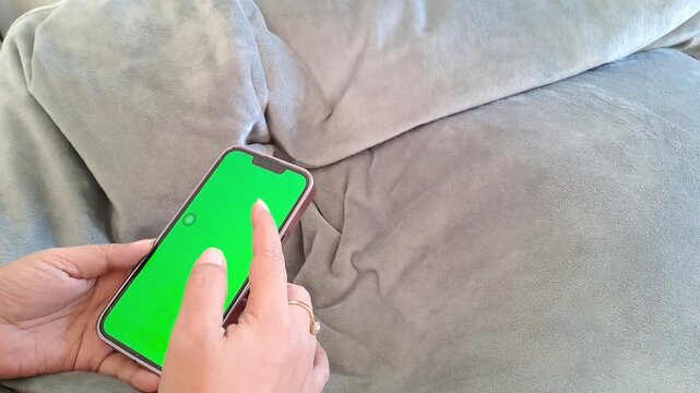 Asian woman hand with ring and bracelet using green screen phone. Scrolling, tapping, social media, unlock. 4K video for iphone, green screen, tech background, technology background, app, mockup.
