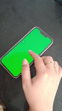 Asian woman hand with ring and bracelet using green screen phone. Scrolling, tapping, social media, unlock. 4K video for iphone, green screen, tech background, technology background, app, mockup.