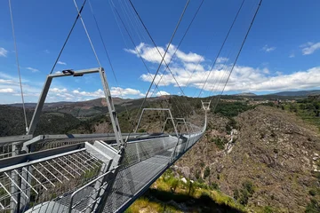 Arouca 516 suspension bridge crossing a dramatic valley in Portugal, showcasing modern engineering, adventure tourism, geometric design, scenic landscapes, and outdoor exploration © esvetleishaya