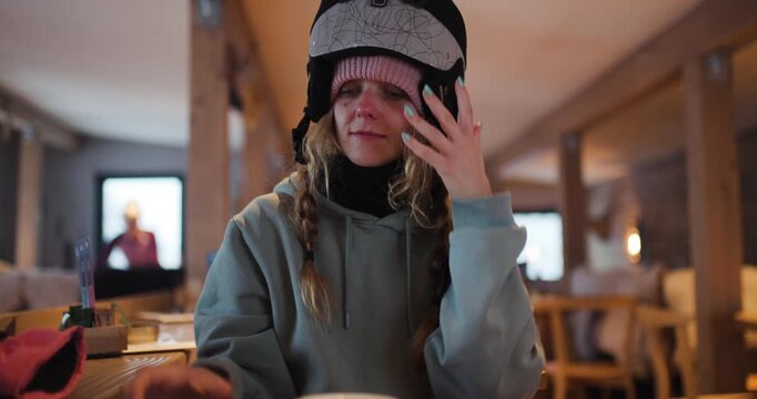Smiling Girl Puts on Ski Helmet on a wrong side, Ready for Winter Sports Adventure