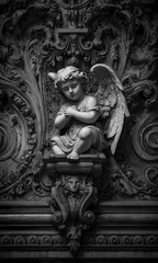Obraz premium Angel sculpture sits on a stone wall.