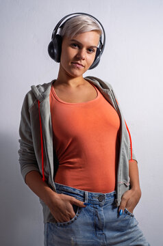 Cool young adult girl with short gray hair  on white background posing with headphones 