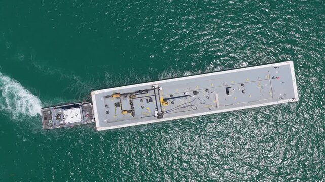 Cargo barge ship in sea, aerial view. Freight container loaded on cargo vessel. Aerial view cargo barge entering harbor. Cargo business. Container ship. Shipping logistics. Commercial shipping