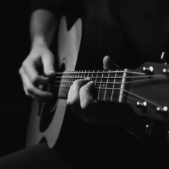 Obraz premium Close-up of a musician's hands playing an acoustic guitar in low light, showcasing intricate finger placement and the texture of the instrument