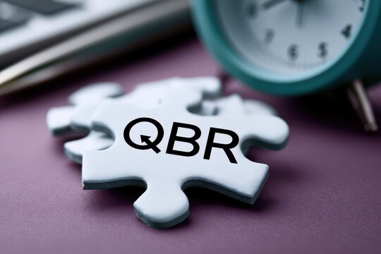 Jigsaw puzzle piece showing QBR on a table. Business review concept.