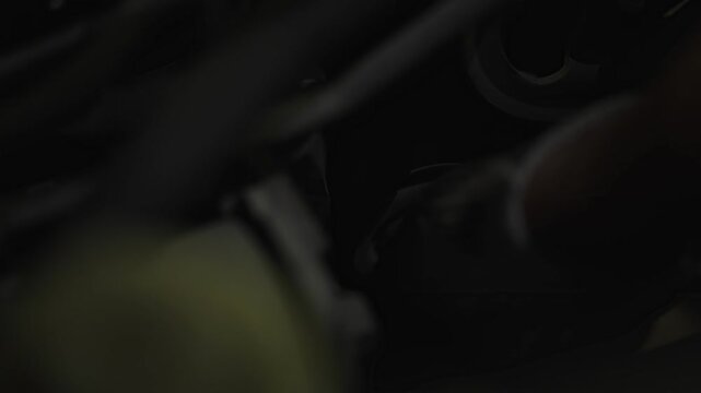 Metal socket wrench tool laying inside a dark car engine compartment