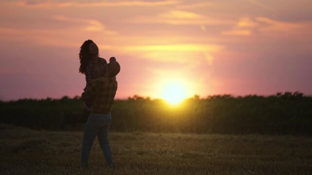 Farmer couple embracing in a rural field at sunset, capturing a warm and romantic moment in the countryside and agricultural lifestyle.