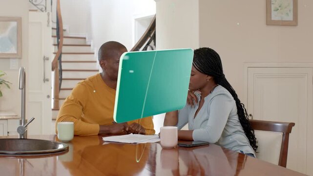 Man pointing to papers and causing green panels appearing, orbiting while couple reviewing finances
