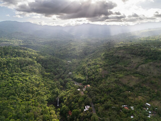 Naklejka premium Mountain view with sunlight shining through clouds over green valley