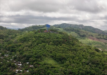 Naklejka premium View of a hilltop site with a blue structure and greenery below