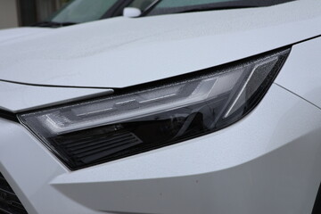 Close-Up of White SUV Headlight © しまかの