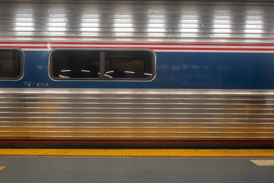 Train side view showing metallic texture and window at station platform