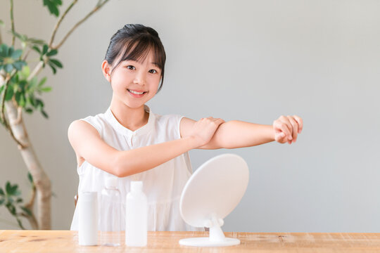 Children, girls, elementary school students, and junior high school students applying sunscreen, skincare, body care, and hand cream.