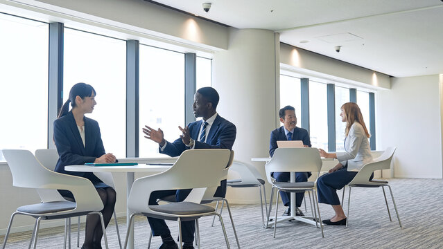 A group of multinational businesspeople conversing in the lobby.