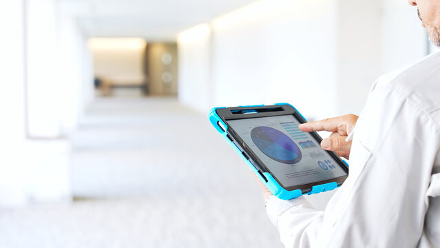 タブレットを見ながら建物をチェックするエンジニア