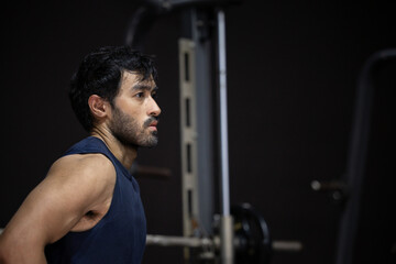 Athlete gym man fitness exercise strength training workout weight muscle concentration side profile portrait of determined adult male in dark indoor gym © 220 Selfmade studio
