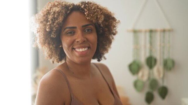Woman smiling and winking, visible cleavage and bra straps, casual natural pose in studio; happiness confidence.