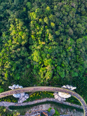 Obraz premium Aerial top view of the bridge hands on top of a mountain surrounded by forest
