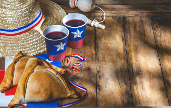 Chilean independence day concept. fiestas patrias. Tipical baked empanadas, fat and play emboque. Decoration for 18 september party day, wooden background