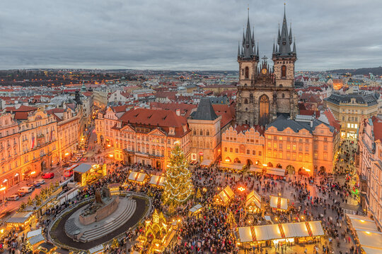 Twilight view of Prague's Old Town Square during the Christmas Market, with the illuminated Church of Our Lady before T&yacute;n towering above festive market stalls in Prague, Czech Republic