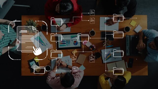 Overhead view of a diverse group collaborating in a modern workspace, engaging in discussions and sharing visual ideas using digital tools and documents. Raster