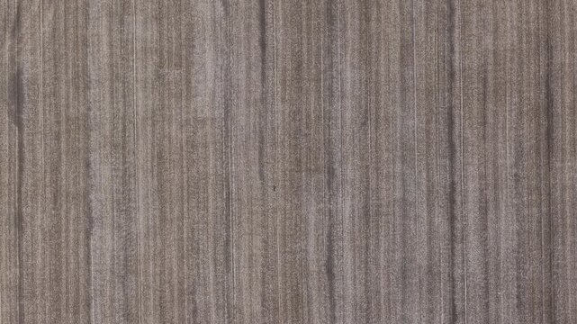 A detailed close-up of vertical dark brown wood grain showing natural organic texture, suitable for architectural backgrounds and design.