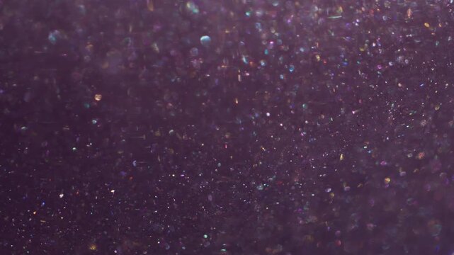 Bokeh leak twirl. Flare glimmer. Gradient color mixing light flow. Shimmering blur particles spill on purple abstract art background.