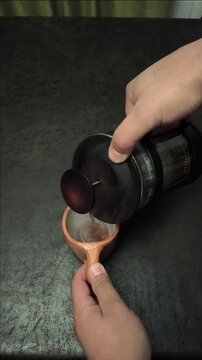 Top down view of hot herbal tea or coffee being poured from a French press into a clay mug