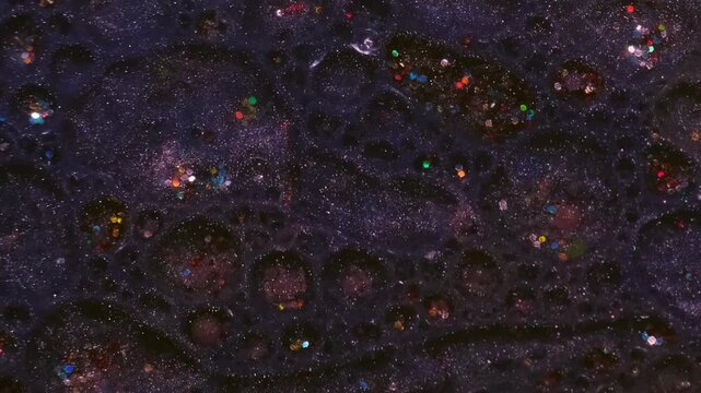 Shiny paint sequins. Oil bubbles. Defocused pink purple blue colorful bright round texture floating on abstract acrylic art background.
