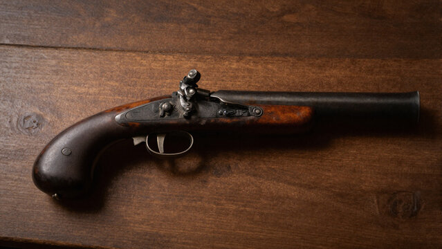 antique flintlock pistol vintage dueling gun on wooden background