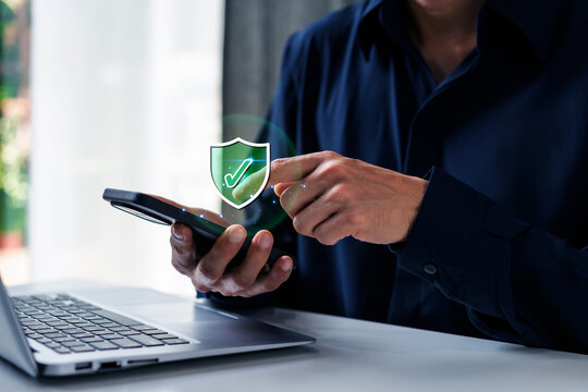 Secure online transactions, Businessman using laptop and smartphone with digital security shield icons for cyber protection