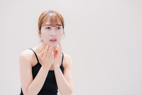 お肌の不調に悩む明るい髪色の若い女性