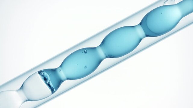 Gas bubbles burst through transparent blue fluid as it fills and drains from a bulb lab condenser on a solid white surface | Oxygenated water skincare formulation development concept