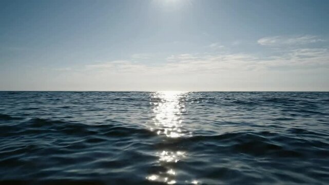 Serene ocean waves at sunset, sparkling sunlight reflection on deep blue sea surface, calm tropical water background, for relaxation and meditation