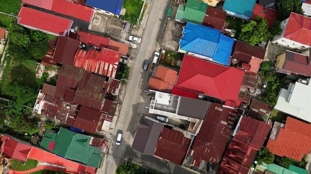 Slow orbit drone footage around CJDC Building in Alfonso Cavite Philippines featuring the commercial structure, adjacent streets, and surrounding townscape.