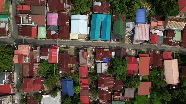 Pullback aerial reveal of CJDC Building and Rizal Street in Alfonso Cavite Philippines showing the relationship between the commercial property and surrounding town roads.