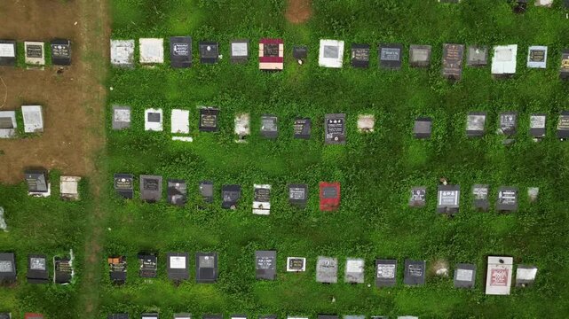 Cinematic orbit aerial shot of Alfonso Public Cemetery in Cavite Philippines with surrounding roads, nearby structures, and a balanced provincial composition from above.