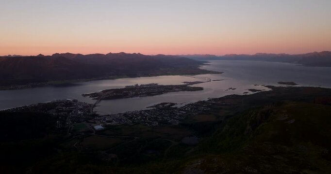 Airplane approaching Stokmarknes Airport in Hadsel Municipality, Norway, over fjord waters, islands and mountain scenery at twilight