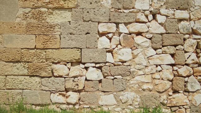 Ancient limestone and mixed masonry wall reveals centuries of restoration techniques at the Swabian Castle in Brindisi, Apulia, Italy, static architectural detail shot.