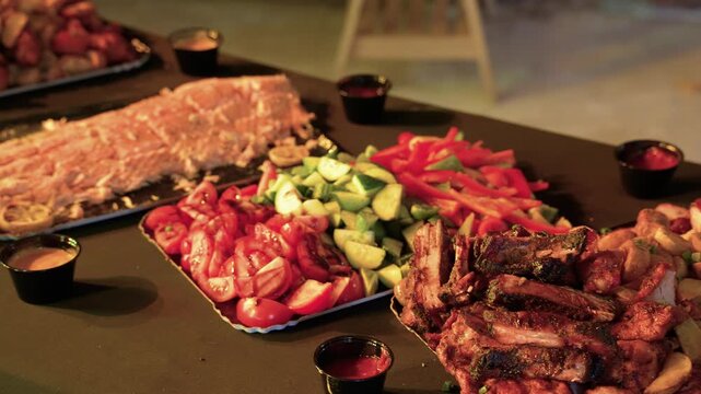 A wide angle shot of a rustic buffet table artfully arranged with barbecue ribs, roasted salmon, grilled chicken, and fresh vegetables under warm, inviting lighting. No people visible.
